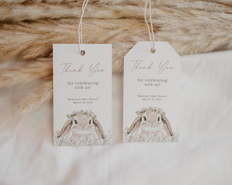 May include: Two white thank you tags with a bunny rabbit illustration and pink floral accents. The text on the tags reads "Thank You for celebrating with us!" and "Madison's Baby Shower March 18, 2022".