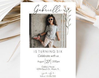 May include: A birthday invitation for a girl named Gabrielle turning six. The invitation features a photo of the girl wearing sunglasses and a pink shirt, with a floral design in the top right corner. The invitation includes the date, time, and location of the party.
