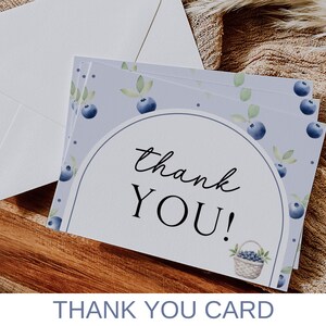 May include: A stack of thank you cards with a watercolor design of blueberries and leaves on a light purple background. The text "thank you!" is printed in black on the front of the cards.