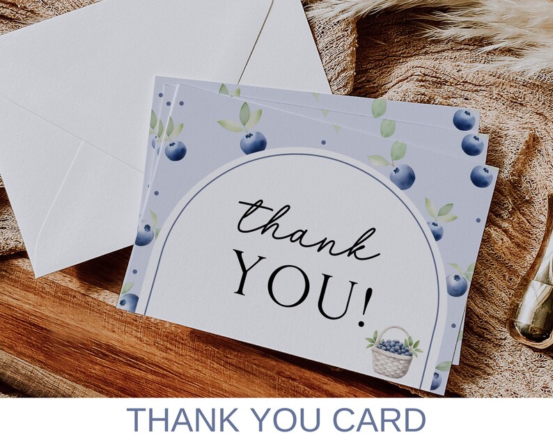 May include: A stack of thank you cards with a watercolor design of blueberries and leaves on a light purple background. The text "thank you!" is printed in black on the front of the cards.