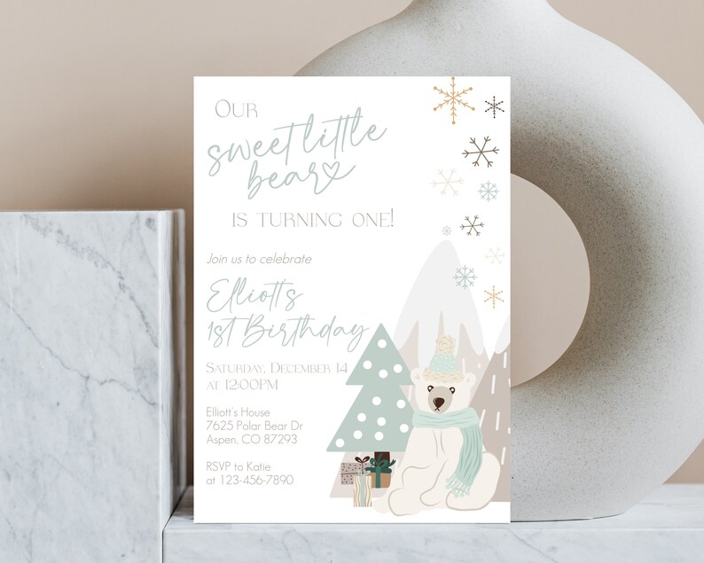 May include: A birthday invitation featuring a polar bear wearing a hat and scarf, with a Christmas tree and mountains in the background. The text reads "Our Sweet Little Bear is Turning One!" and includes event details.
