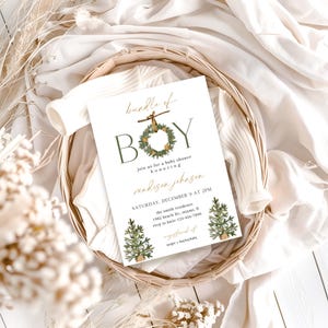 May include: A baby shower invitation with the text "bundle of BOY" in green and gold. The invitation includes details like the date, time, location, and RSVP information, and is decorated with illustrations of wreaths and Christmas trees.