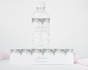 May include: Water bottle label with a watercolor floral design in shades of blue and white. The label says "Amelia's Baby Shower".