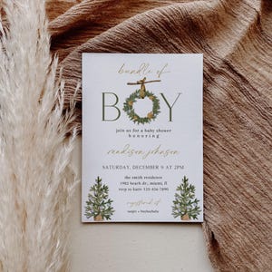 May include: Baby shower invitation with the words "bundle of BOY" in green and gold. The invitation includes details for the event, such as the date, time, and location. The invitation is decorated with illustrations of Christmas trees.