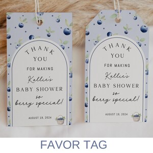 May include: Two blue and white favor tags with a blueberry design. The text on the tags reads "Thank You for making Kallie's Baby Shower so berry special!" with the date August 19, 2024.
