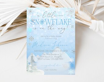 Op de afbeelding: Een blauwe en witte babyshower-uitnodiging met een sneeuwvlokdesign. De uitnodiging luidt "a little snowflake is on the way!" en bevat de naam "Madison Johnson", de datum en tijd van de babyshower, de locatie en RSVP-informatie. De uitnodiging bevat ook de tekst "registered at Target + BuyBuyBaby".