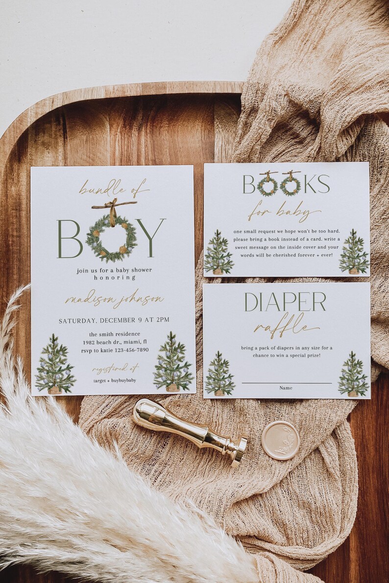 May include: Baby shower invitation suite with a rustic theme. The invitation features the word "BOY" with a wreath, and the text "bundle of" above it. Includes cards for books and a diaper raffle, plus a gold wax seal.