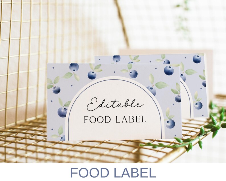May include: Editable food label with a watercolor design of blueberries and leaves on a light blue background. The text "Editable Food Label" is printed in black.