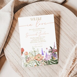 May include: A bridal shower invitation with a floral design. The invitation reads "WILDLY in love" and includes the name "Savannah Jackson" and details for the event.