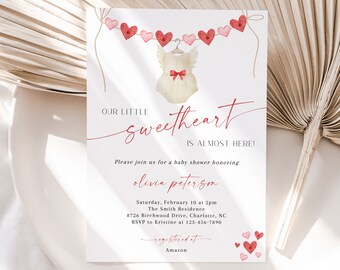Puede incluir: Invitación a un baby shower con diseño de acuarela. La invitación presenta una pancarta de corazones y un body de bebé. El texto dice "Our Little Sweetheart Is Almost Here!" e incluye detalles del evento.