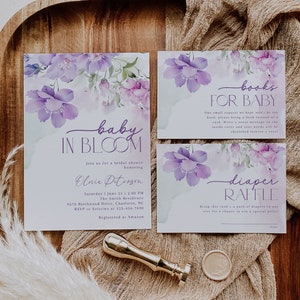 May include: Purple floral baby shower invitation with the text "baby in bloom" and details for the event.  The invitation also includes a separate card for a diaper raffle and a card for a book request for the baby.