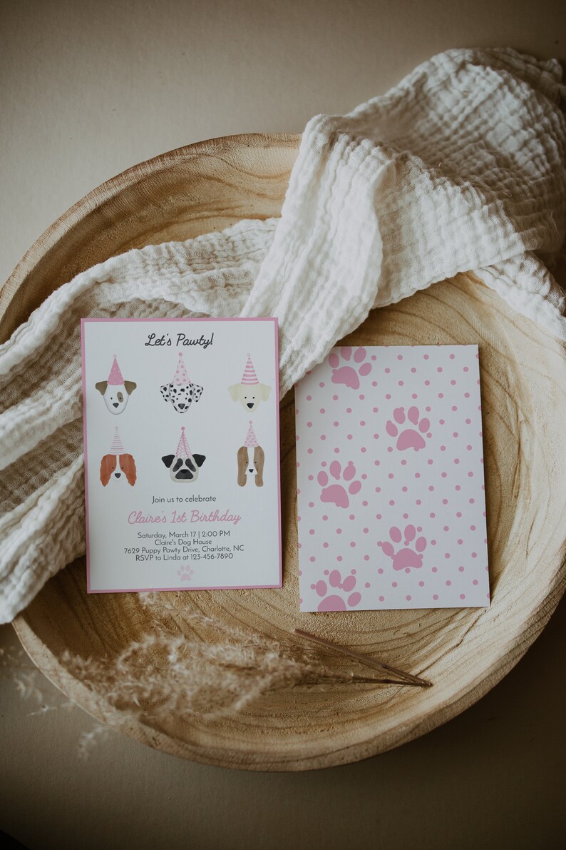 May include: A pink and white paw print patterned invitation card with the text "Let's Pawty!" and "Claire's 1st Birthday" with a list of details for the party.