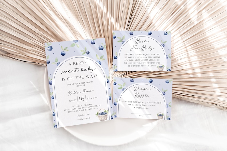 May include: A set of three baby shower cards with a blueberry theme. The invitation card says "A Berry Sweet Baby is on the Way!" with a date and time. The other two cards are for a book and diaper raffle.