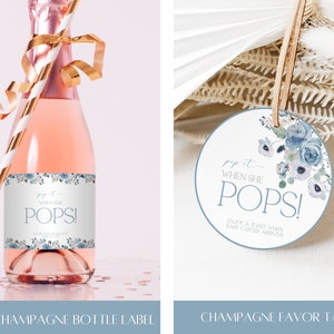 K&ouml;nnte beinhalten: Ein Mini-Champagner-Flaschenetikett mit blauem und wei&szlig;em Blumenmuster mit dem Text "Pop it when she pops!" und ein passendes rundes Champagner-Geschenk-Etikett mit dem Text "Pop it when she pops! Enjoy a toast when baby Carter arrives."