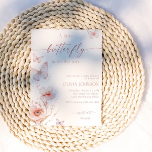 May include: A baby shower invitation with a watercolor butterfly design. The invitation is for Olivia Johnson and is set for Saturday, March 5 at 1:2PM at The Smith Residence, 7204 Birchwood Drive. RSVP to 123-456-7850. The invitation also includes a link to a baby registry.