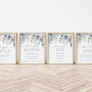 May include: Four printable signs with a blue floral design. The signs say "Diaper Raffle", "Late Night Diapers", "Mimosa Bar", and "Don't Say Baby".