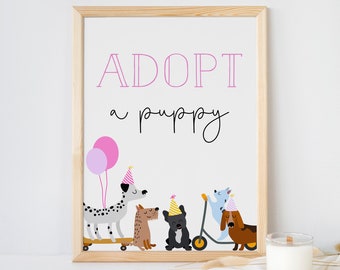 May include: A framed print with the text "ADOPT a puppy" in pink and black lettering. The print features a line of cartoon dogs wearing party hats and riding scooters and skateboards.