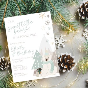 May include: A birthday invitation with a winter theme. The invitation features a polar bear wearing a hat and scarf, with a Christmas tree and presents. The text reads "Our sweet little beary is turning one!" and includes party details.