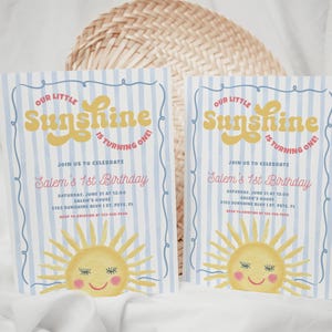 May include: Two invitations with a blue and white striped background. The invitations read "Our Little Sunshine is Turning One!" in yellow and red text. A smiling sun graphic is at the bottom.