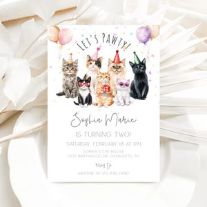 Op de afbeelding: Een kleurrijke verjaardagsuitnodiging met een pootprintontwerp en de tekst "Let's Pawty!" Sophia Marie wordt twee jaar. De uitnodiging toont een groep katten die feestmutsen dragen en omringd zijn door confetti. De uitnodiging bevat de datum, tijd en locatie van het feest.