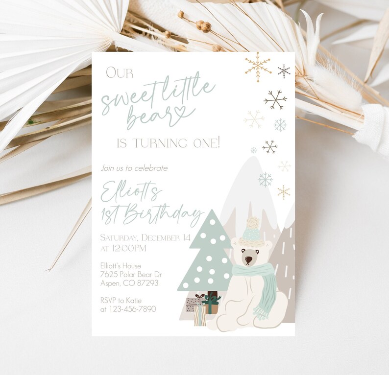 May include: A birthday invitation with a winter theme. The text reads "Our sweet little beary is turning one!" and "Elliotts 1st Birthday". The design includes a polar bear wearing a hat and scarf, a Christmas tree, snowflakes, and mountains.