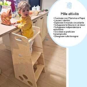 Puede incluir: Un taburete de madera clara con tres pelda&ntilde;os y un pasamanos. Un ni&ntilde;o peque&ntilde;o est&aacute; de pie en el pelda&ntilde;o superior, alcanzando un mostrador. El taburete est&aacute; dise&ntilde;ado para ayudar a los ni&ntilde;os a alcanzar superficies m&aacute;s altas de forma segura.