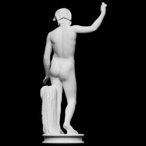 A small white 3D sculpture print of the Statue of Liberty is placed between two potted plants.