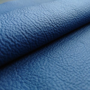 May include: Close-up of a blue leather fabric with a textured surface.