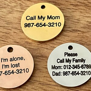 May include: Three round metal pet ID tags with black engraved text. The gold tag reads "Call My Mom 987-654-3210". The copper tag reads "If I'm alone, I'm lost 987-654-3210". The silver tag reads "Please Call My Family Mom: 012-345-6789 Dad: 987-654-3210".