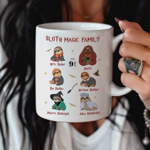 May include: White ceramic mug featuring the text "SLOTH MAGIC FAMILY" and illustrations of sloths dressed as characters. The characters include "Harty Slother", "Hagrid", "Ron Slothley", "Hermione Slothger", "Minetua Slothnagall", and "Albus Slothbledore".