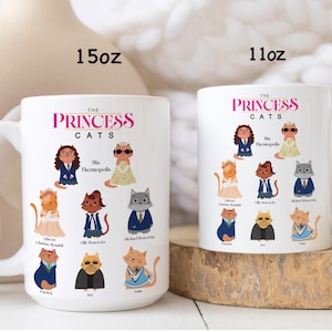 May include: Two white ceramic mugs, one 15oz and one 11oz, featuring the text THE PRINCESS CATS and illustrations of nine cats dressed as characters. Each cat is labeled with names including Mia Thermopolis, Queen Clarisse Renaldi, Lilly Moscovitz, Michael Moscovitz, Patrick, Joe, and Lana.