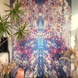 Peut inclure: Une grande tapisserie avec un motif abstrait vibrant dans les tons de bleu, violet et rouge. L'œuvre présente un motif symétrique avec un point central. La tapisserie est exposée avec des plantes et des cristaux décoratifs.