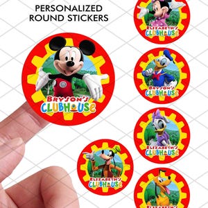 May include: A hand holding a round sticker featuring Mickey Mouse with the text "BRYSON'S CLUBHOUSE". Other stickers show Minnie Mouse, Donald Duck, Goofy, Daisy Duck, and Pluto. The stickers are red with yellow gear-like borders and the text "PERSONALIZED ROUND STICKERS".