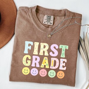 Camiseta Comfort Colors® para primer grado: camiseta pastel para el regreso a clases para niños o maestros, linda camiseta con letras de arcoíris, camiseta genial para el grado.