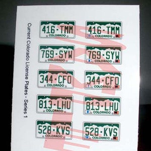May include: A sheet of paper with eight different Colorado license plates printed on it. The plates are all green and white with the state name "Colorado" printed on them. The plates have different numbers and letters on them, such as "416-TMM", "769-SYW", "344-CFO", "813-LHU", and "528-KVS". The text "Current Colorado License Plates - Series 1" is printed on the left side of the sheet.