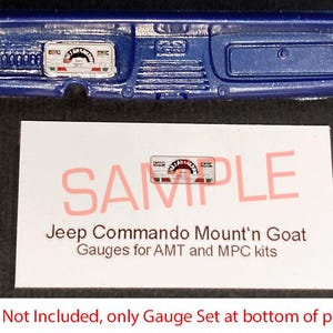May include: A blue plastic dashboard model with gauge details. The image includes a card with the text "SAMPLE" and "Jeep Commando Mount'n Goat Gauges for AMT and MPC kits."