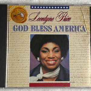 May include: CD case for Leontyne Price's "God Bless America" album. The cover features a portrait of the singer, with text in blue and gold. The RCA Victor Gold Seal logo is visible.