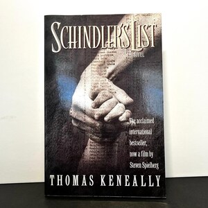 May include: A book cover for "Schindler's List" by Thomas Keneally. The cover features the title in a stylized font, with a grayscale image of clasped hands. Text on the cover highlights the book's acclaim and its adaptation into a film by Steven Spielberg.
