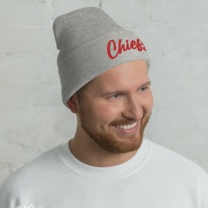 May include: A gray beanie with the word "Chiefs" embroidered in red on the front.
