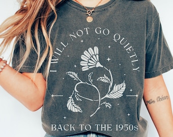 Może przedstawiać: Szary t-shirt z białym nadrukiem przedstawiającym stylizowaną kwiatową grafikę z tekstem "I Will Not Go Quietly Back To The 1950s".