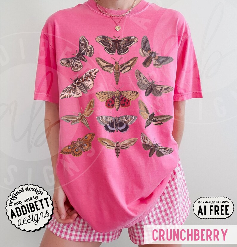 May include: A bright pink short-sleeve t-shirt featuring a graphic print of various moth species in shades of brown, tan, and black. The shirt has a crew neckline and is paired with pink and white gingham patterned shorts.
