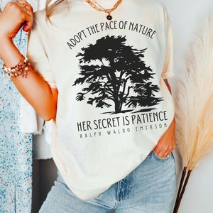May include: A cream coloured t-shirt with a black silhouette of a tree and the text "Adopt the pace of nature. Her secret is patience. Ralph Waldo Emerson."