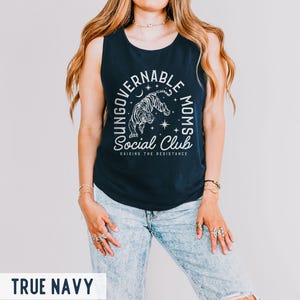 Puede incluir: Camiseta sin mangas azul marino con el texto "UNGOVERNABLE MOMS Social Club" y un gr&aacute;fico de tigre. El texto "RAISING THE RESISTANCE" est&aacute; debajo. La camiseta sin mangas es sin mangas y de material suave.