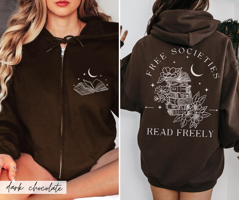 May include: Dark chocolate brown zip-up hoodie with a white graphic of an open book and crescent moon on the front. The back features the text "FREE SOCIETIES" and "READ FREELY" with a stack of books, flowers, and a crescent moon.
