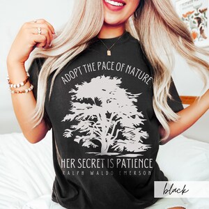 May include: Black t-shirt with a white graphic of a tree and the text "Adopt the pace of nature. Her secret is patience. Ralph Waldo Emerson."