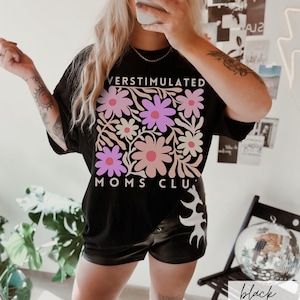 May include: Black oversized t-shirt with a floral design and the text "Overstimulated Moms Club".