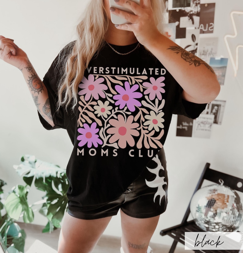 May include: Black oversized t-shirt with a floral design and the text "Overstimulated Moms Club".
