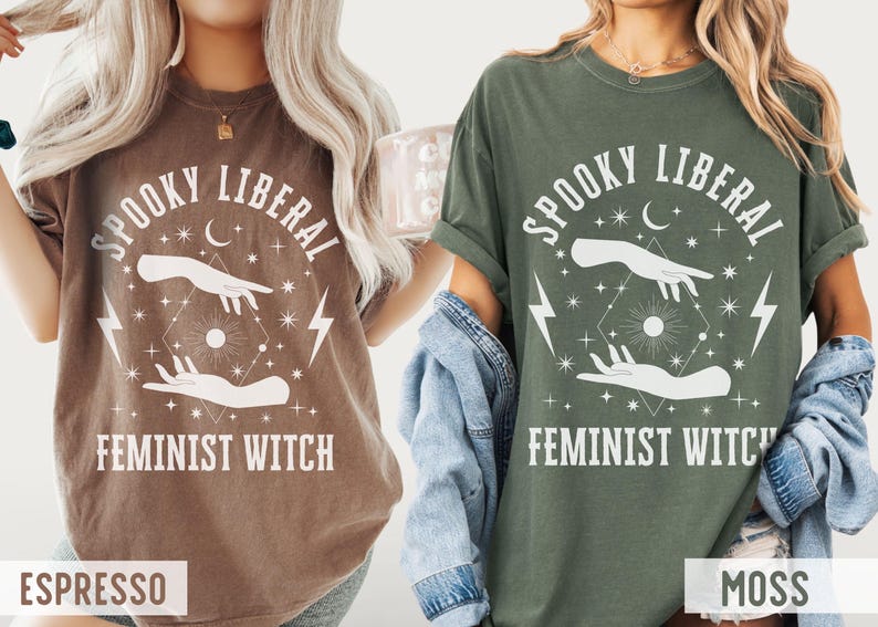 Puede incluir: Dos camisetas, una marr&oacute;n expreso y otra verde musgo, cada una con el texto "Spooky Liberal Feminist Witch" en blanco. El dise&ntilde;o incluye manos, rayos, estrellas y una luna creciente. Las camisetas son exhibidas en una persona.