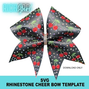 May include: A black cheer bow featuring a repeating pattern of red cherries with green stems and leaves, embellished with scattered clear rhinestones. The centre of the bow is cinched with a band of multi-coloured rhinestones. Text reads RICH GIRL.