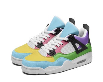 May include: A pair of white, yellow, blue, green, and purple sneakers with black accents. The sneakers have a mesh and leather upper and a white rubber sole.